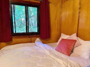 una cama en una habitación con ventana en 2-bedroom Balsam Lake Lower Boathouse #1A, en Kawartha Lakes