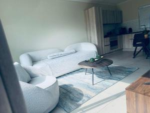 a living room with a white couch and a table at Manhattan Corner in Cape Town