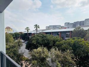 a view of a parking lot with palm trees and buildings at Manhattan Corner in Cape Town