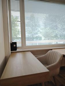 a table and a chair in front of a window at Rauhallinen majoitus parvekkeella in Joensuu