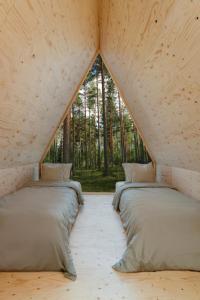 Dos camas en una habitación con una gran ventana. en Forest View Cottage, 