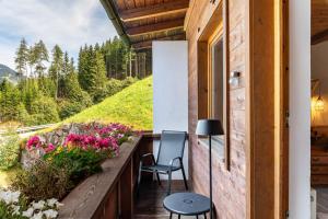 a balcony with flowers and a table and chairs at A Nett’s Nest in Hainzenberg