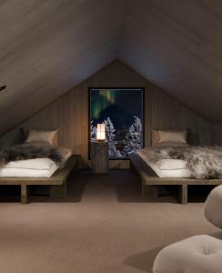 a room with two beds and a tv on the wall at North Suite Nova by Hilla Villas in Kittilä