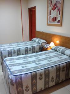 a hotel room with two beds and two nightstands at Hostal Aeropuerto in Madrid