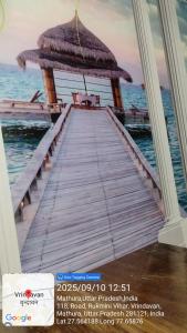 a picture of a pier with an umbrella on the water at Hotel Aditya in Vrindāvan