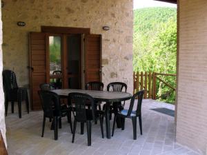 a wooden table and chairs on a patio at Casale Coccinella in Preci