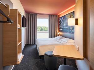 a hotel room with two beds and a table at B&B HOTEL Emmerich in Emmerich