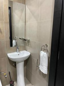 a bathroom with a white sink and a mirror at Cozy & Modern Studio in Nairobi West in Nairobi +5 photos