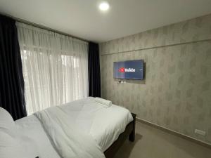 a bedroom with a bed and a tv on the wall at Cozy & Modern Studio in Nairobi West in Nairobi