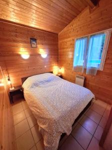 a bedroom with a bed in a wooden room at Jolie Cabane Océan in Vielle-Saint-Girons +26 photos