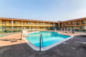 a swimming pool in front of a building at Quality Inn & Suites near Downtown Bakersfield in Bakersfield