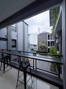 a balcony with a glass table and chairs on it at M-LIVIN Hotel in Pangkalpinang