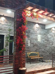 a patio with a bench and flowers on a brick wall at Half Moon Chalet شالية نصف القمر in Duwaykhīlah +4 photos