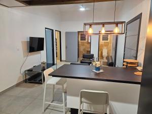 a kitchen and living room with a table and chairs at Villa Capucine in Saint-Paul