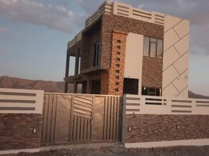 a house with a fence in front of it at Half Moon Chalet شالية نصف القمر in Duwaykhīlah