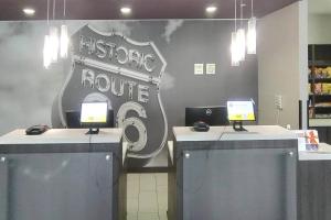 ClaremoreにあるComfort Inn & Suitesの机が2つあり、その上にコンピューターが2台ある店