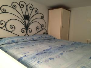 a bedroom with a large bed with a metal headboard at Casa Azzurra in Ischia
