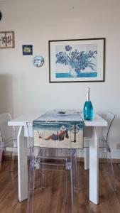 a dining room table with a glass top and a table at Terrazza Fiumara in Letojanni +9 photos
