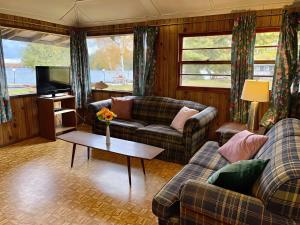 Una sala de estar con dos sofás y un televisor. en Balsam Lake - 2-Bedroom Cottage #2, en Kawartha Lakes