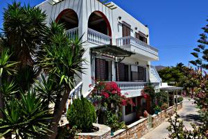 a white house with flowers and plants in front of it at Stelios Zalonis Apartments in Tinos