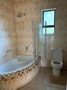 a bathroom with a bath tub and a toilet at Fuleng Guest House - Quthing in Quthing +27 photos