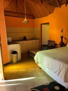 a bedroom with a bed and a kitchen in a room at Fuleng Guest House - Quthing in Quthing