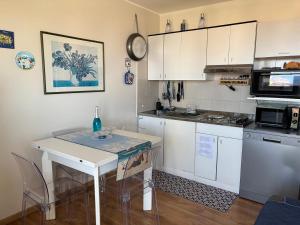 eine Küche mit weißen Schränken und einem weißen Tisch in der Unterkunft Terrazza Fiumara in Letojanni