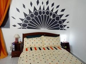 a bedroom with a bed with a large painting on the wall at Iroko Plage San Pédro in San-Pédro