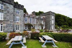 dos mesas de picnic frente a un castillo en The Castle en Castlehaven