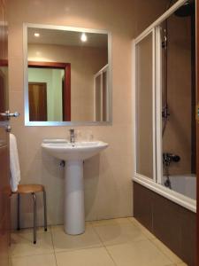 a bathroom with a sink and a mirror and a tub at Hostal Aeropuerto in Madrid