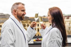 a man and a woman holding glasses of wine at Theresian Hotel in Olomouc