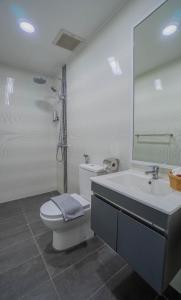 コタキナバルにあるAeropod Suites - Deluxe Family - by J-Residencesのトイレと洗面台を備えた白いバスルーム