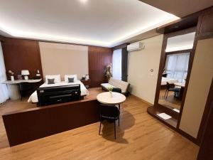 a hotel room with a bed and a table and a bedroom at M-LIVIN Hotel in Pangkal Pinang