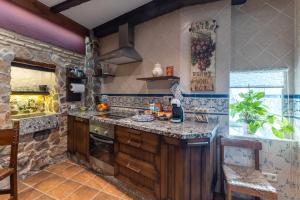 a large kitchen with a stone wall at El Rincon De San Jose in Marjaliza +12 photos