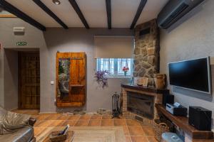 a living room with a fireplace and a flat screen tv at El Rincon De San Jose in Marjaliza