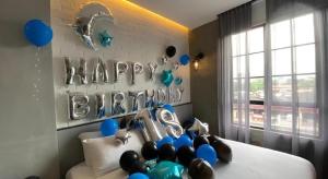a room with balloons and a happy birthday sign on a bed at Atelier Hotel Johor Bahru in Johor Bahru