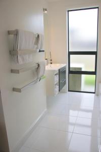 a bathroom with white towels and a sink and a mirror at Karapiro Lakeside in Karapiro +16 photos