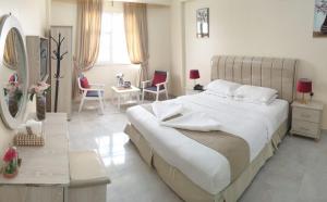 a bedroom with a large bed and a table and chairs at جزيرة اللؤلؤ للشقق الفندقية PEARL ISLAND HoTEL APARTMENT in Al Buraymī