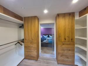 ルーポルディングにあるFerienhaus, Abenteuer, Alpen, Auszeit Ruhpoldingの木製キャビネット付きの部屋、ベッド付きのベッドルーム1室が備わります。