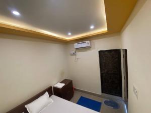 a small room with a bed and a air conditioner at Hotel Atulya in Patna