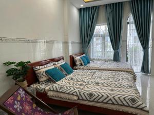 two beds in a bedroom with green curtains at Căn Hộ 3 PN Rin's House in Phan Thiet