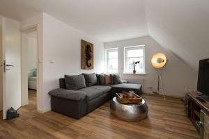 a living room with a couch and a table at Sylter Seestern Seepferdchen Loft in Morsum