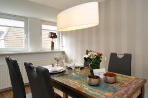 a dining room table with a vase of flowers at Sylter Seestern Seepferdchen Loft in Morsum