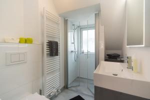 a white bathroom with a shower and a sink at Sylter Seestern Seepferdchen Loft in Morsum +20 photos