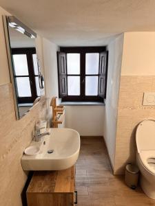 a bathroom with a sink and a toilet and a mirror at glamour home arezzo in Arezzo +7 photos