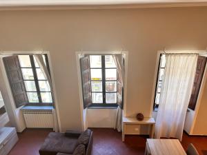 a living room with two windows and a couch at glamour home arezzo in Arezzo