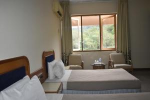 テノムにあるHotel Perkasa Tenomのベッドが2つと窓があるホテルの部屋 +8枚の写真