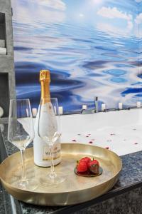a bottle of champagne and two glasses on a tray at Old Town Spa & Fun in Bucharest
