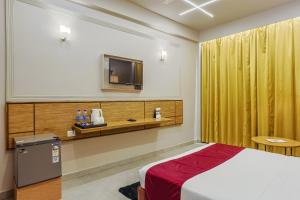 a hotel room with a bed and a tv at Max Hotels Prayagraj in Allahābād