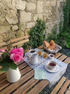 a table with tea and croissants and a vase of flowers at Chambre d'hôtes charme Le Trèfle près du Futuroscope Petit-déjeuner in Bonneuil-Matours